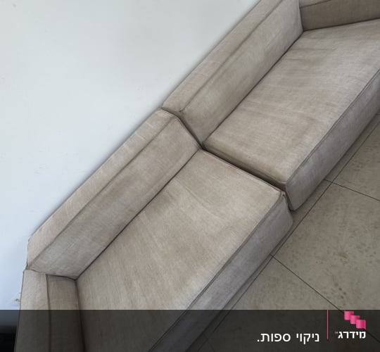 ספה בהירה על רצפת אריחים